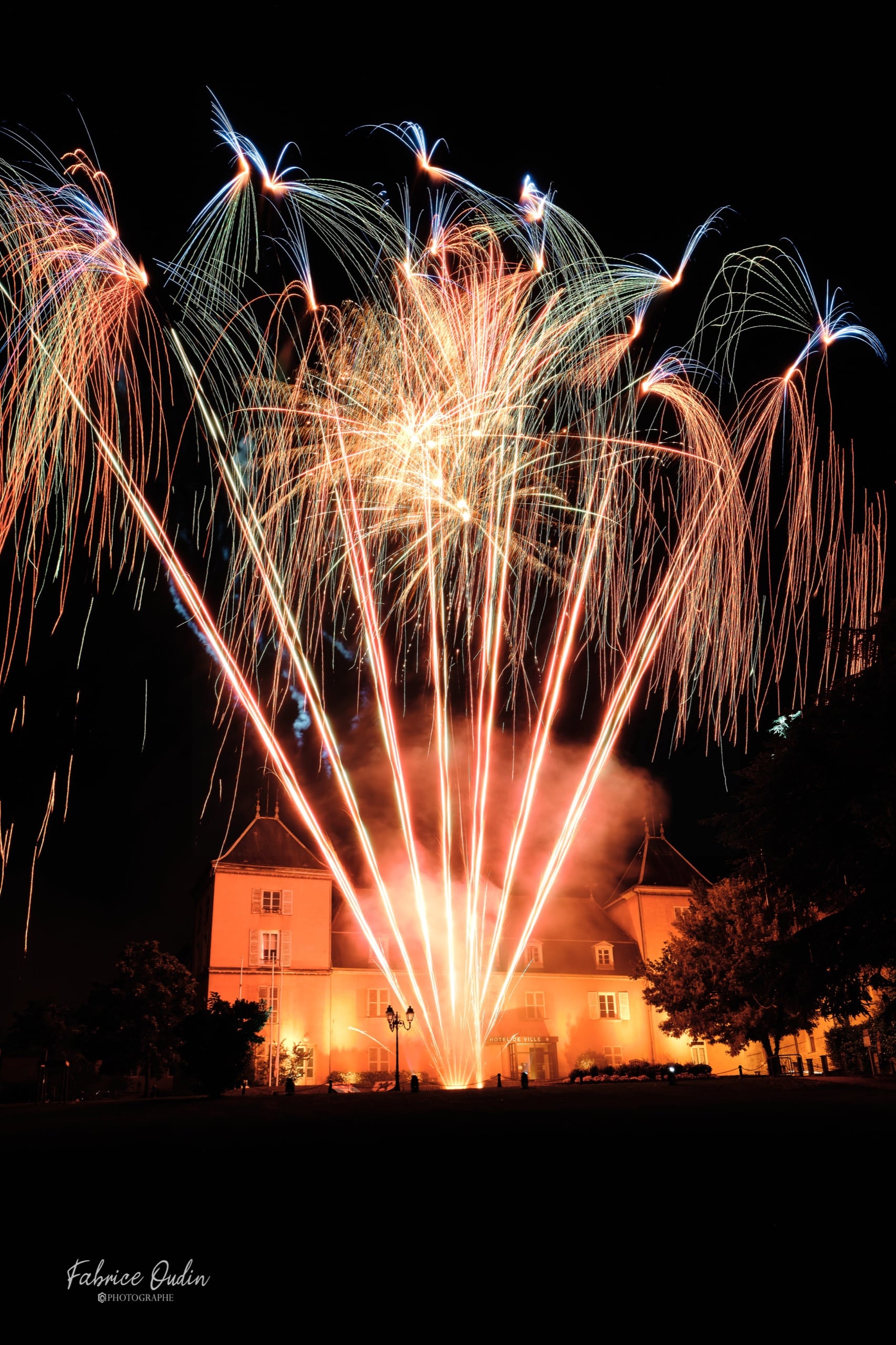 Feu d’artifice au-dessus d’une mairie illuminée